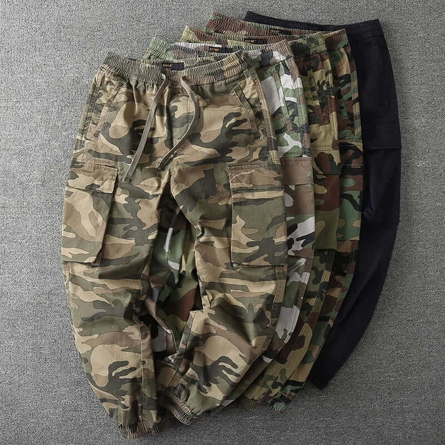 Men's camouflage military pants in various colors displayed on a gray background.