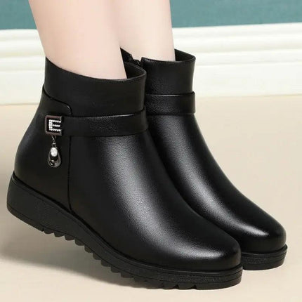 Bota negra de cuero genuino para mujer con diseño bajo, forro polar y suela gruesa, ideal para invierno y uso urbano.
