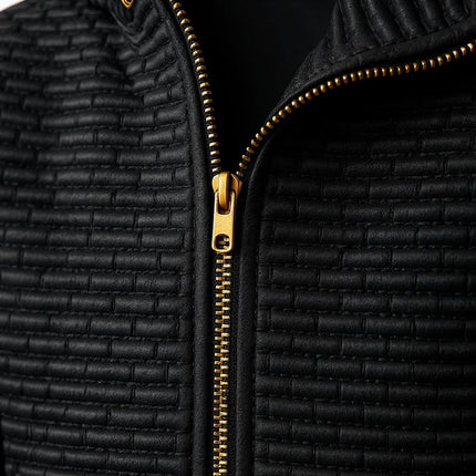 Campera negra acolchada de hombre con cremallera dorada, hecha de suave viscosa para abrigar con estilo y comodidad.