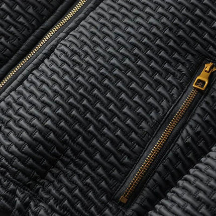 Detalle de campera acolchada negra para hombre, con cremalleras doradas y tejido de viscosa de alta calidad.