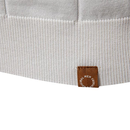 Detalle de chomba Jacques Remy para hombre, algodón beige con canalé vertical y etiqueta marrón de cuero sintético.