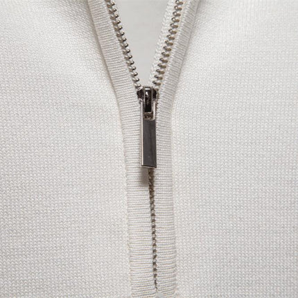 Cierre metálico en tela blanca, textura de canalé vertical, detalle del diseño en un polo de estilo moderno para hombre.