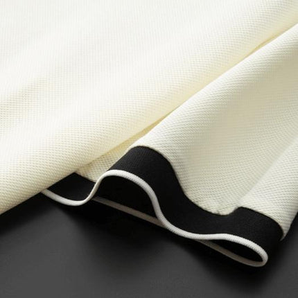Polo Odyssey para hombre, color crema con ribete negro, tejido de punto suave y caída relajada.