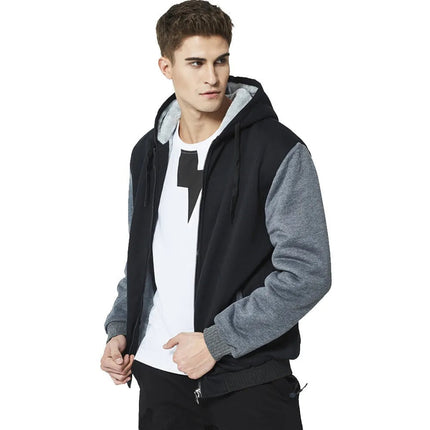 Hombre con conjunto de buzo y pantalón polar en negro y gris, ideal para invierno, con capucha y cierre frontal, estilo moderno.