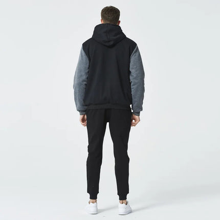 Hombre de espaldas con conjunto de buzo con capucha y pantalón polar negro/gris, ideal para invierno, estilo relajado.