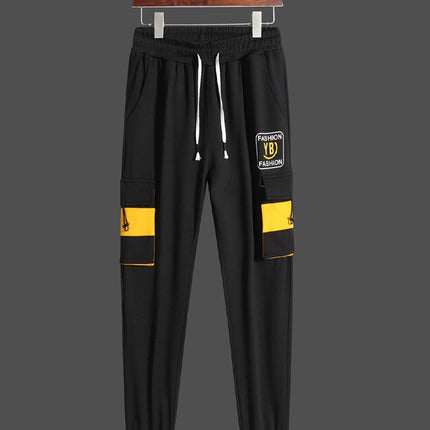 Pantalón deportivo urbano para hombre color negro con detalles amarillos, cintura elástica, ideal para uso diario.