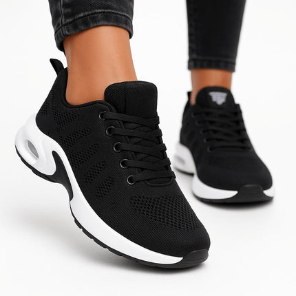 Zapatillas deportivas para mujer en color negro con diseño transpirable y suela blanca ultraligera.