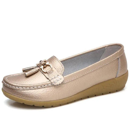 Zapatilla tipo mocasín dorada de mujer, material sintético acabado cuero, diseño elegante y cómodo para uso diario.
