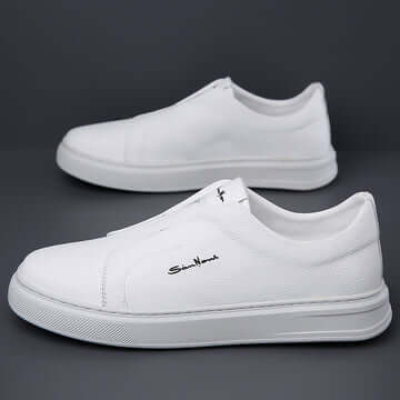 Zapatillas urbanas blancas de cuero genuino para hombres, estilo moderno y minimalista, sobre fondo gris.