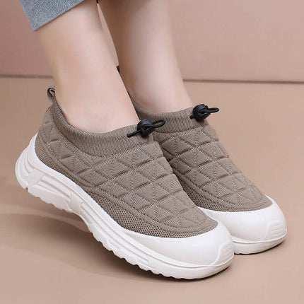Zapato SoftWalk Urban de mujer, color gris claro, tejido elástico transpirable, suela blanca, diseño moderno y cómodo.