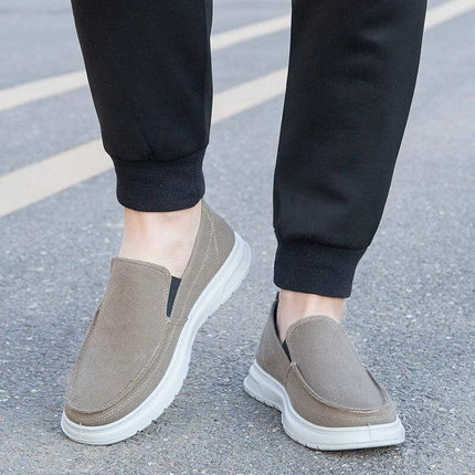 Zapatos de lona gris para hombre, ideales para caminar y uso casual, diseño slip-on y suela blanca resistente.