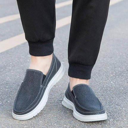 Zapatos de lona casual grises para hombre, ideales para caminar, con suela blanca, diseñados para uso urbano.
